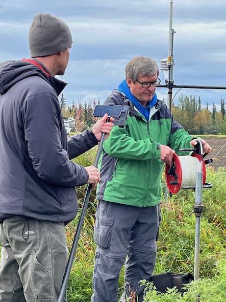 Geoffrey Bruce filming Vladimir Romanovsky taking borehole temperature measurements